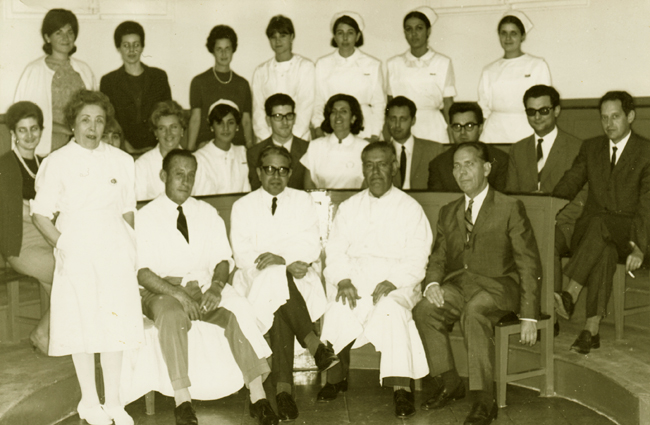 El professor Joaquim Piñol i Aguadé, assegut al centre amb ulleres, amb l’equip de l’Escola de Dermatologia de l’Hospital Clínic de Barcelona. Barcelona c. 1968. [Família Piñol Rull]